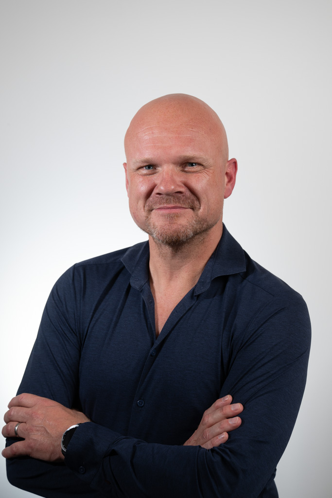 Foto van man in een donkerblauwe bloes.